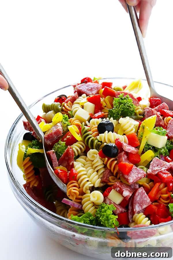 Tossing the Rainbow Antipasto Pasta Salad for even coating