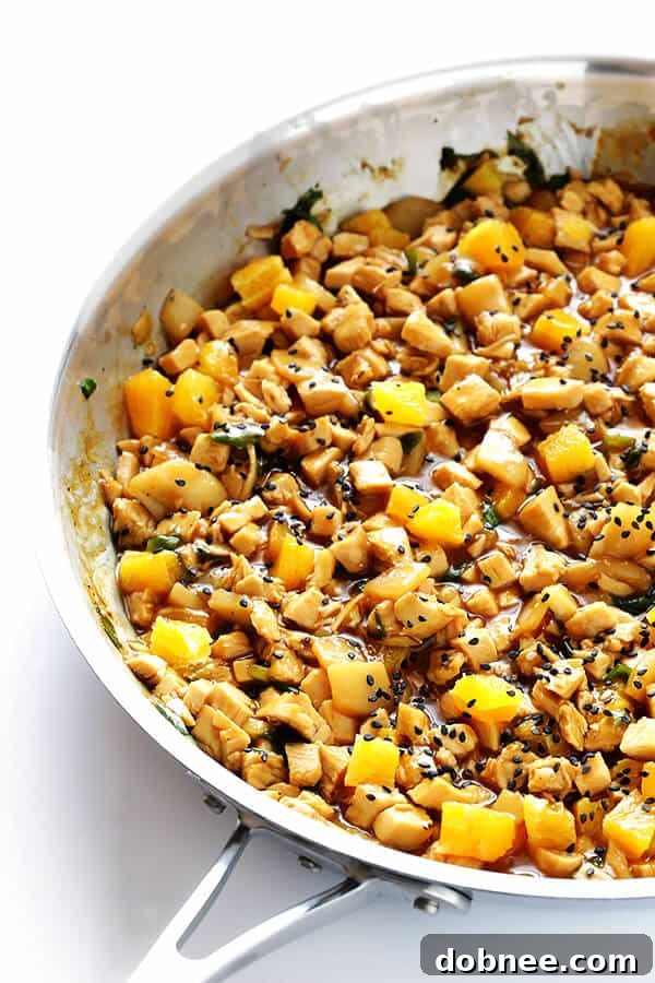 Prepping fresh ingredients like chopped chicken, water chestnuts, fresh orange, and green onions for healthy Orange Chicken Lettuce Wraps.