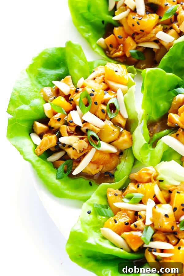 Finished Orange Chicken Lettuce Wraps, garnished with almonds, sesame seeds, and green onions, ready to be enjoyed.