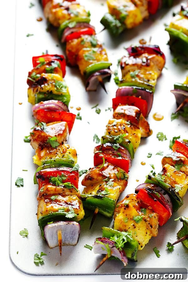 Skewers of Rainbow Hawaiian Chicken Kabobs, marinated in teriyaki sauce, with colorful vegetables and pineapple, ready for grilling.