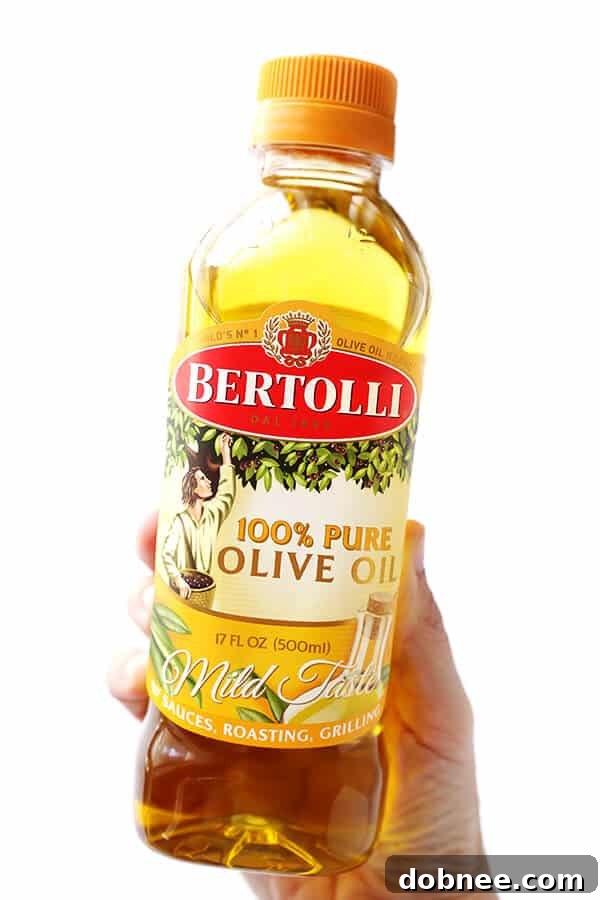 A close-up of a Bertolli 100% Pure Olive Oil bottle, highlighting its suitability for high-heat cooking.