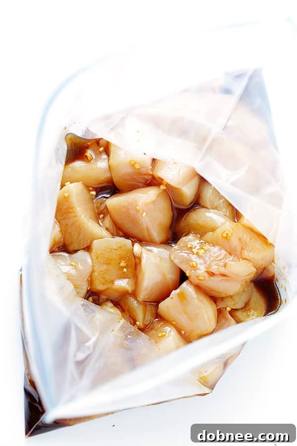 Chicken pieces marinating in a flavorful Hawaiian teriyaki sauce, preparing for the kabobs.