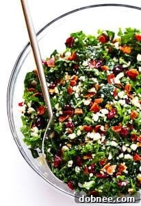 A close-up of a vibrant Kale Salad with Bacon and Blue Cheese, featuring fresh green kale, crispy bacon bits, crumbled blue cheese, and toasted pecans, all glistening with a red wine shallot vinaigrette.