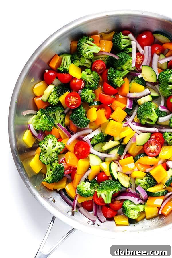 Fresh, colorful vegetables being sautéed in a pan, preparing for the delicious pasta salad.