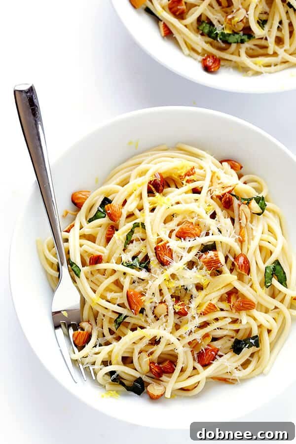 The finished Lemon Basil Spaghetti with Almonds, perfectly tossed and glistening, ready to be served. The texture and colors promise a delightful experience. | gimmesomeoven.com