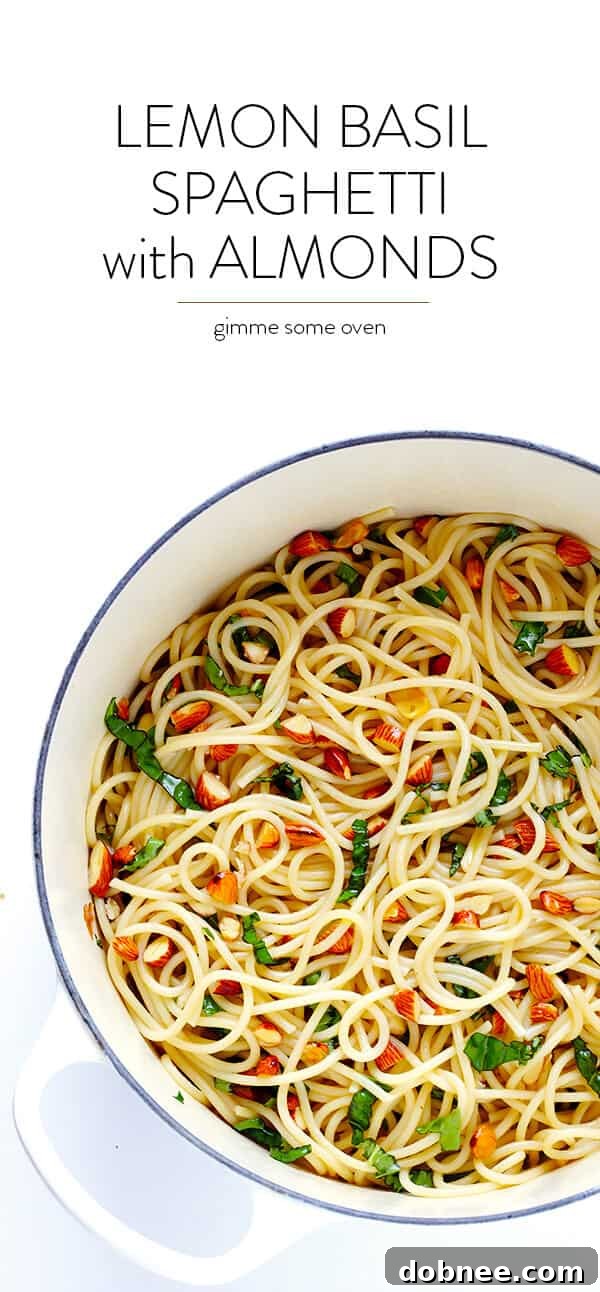 A beautifully presented bowl of Lemon Basil Spaghetti with Almonds, garnished with fresh basil leaves, lemon zest, and grated Parmesan cheese. | gimmesomeoven.com