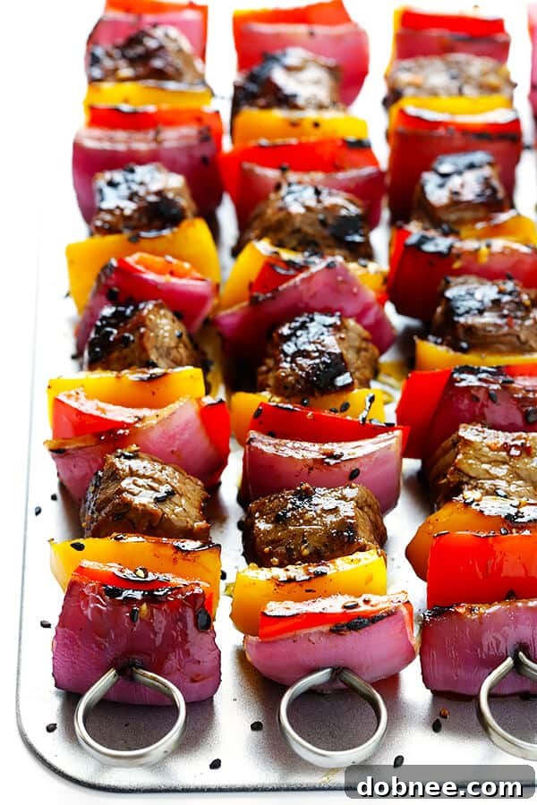Assembling Korean Steak Kabobs with marinated steak, bell peppers, and red onions on skewers, brushed with sauce for grilling. | dobnee.com