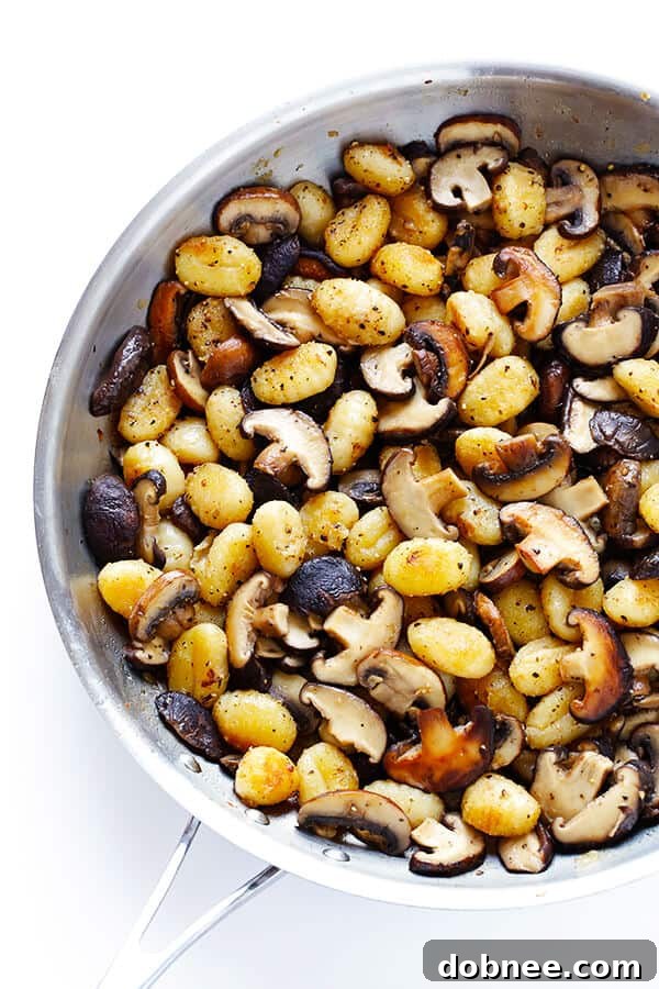 Sautéed mushrooms cooking in a pan with melted butter, releasing their savory aromas