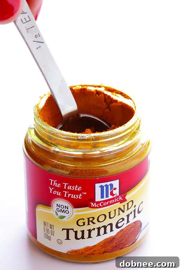 A close-up of the vibrant yellow pineapple turmeric smoothie in a clear glass.