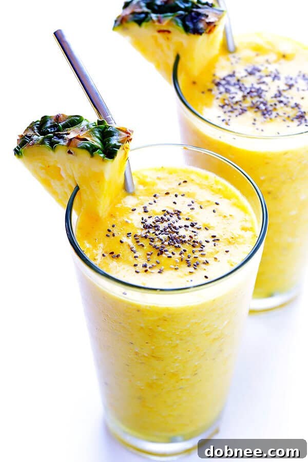 The finished Feel-Good Pineapple Smoothie poured into a glass, garnished with fresh pineapple wedges and a sprinkle of chia seeds.