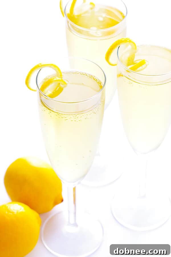 Overhead shot of two French 75 cocktails with lemon twists, ready for a toast.