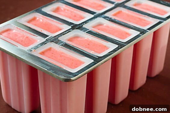 Close-up of a Strawberry Lime Yogurt Popsicle, showcasing its refreshing texture