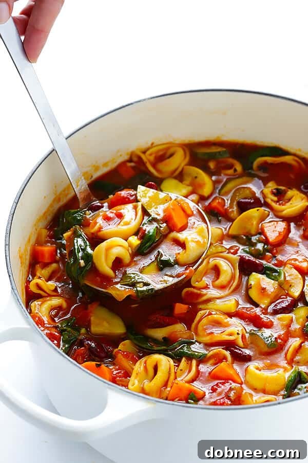 A close-up shot of homemade Tortellini Minestrone, showing the rich broth, colorful vegetables like zucchini and carrots, and delicate cheese-filled tortellini ready to be served. Ideal for comfort and warmth.