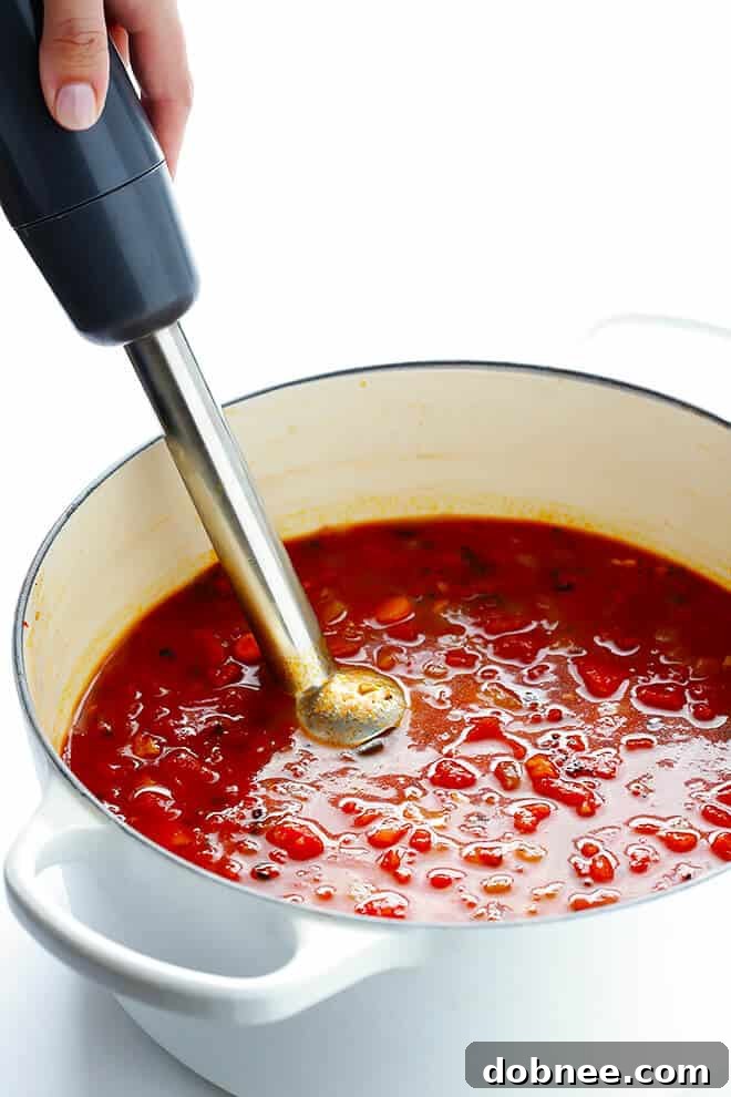 Preparing the 20-Minute Tomato Soup: Sautéing onions and garlic in a saucepan, the foundational step for building rich flavors quickly.