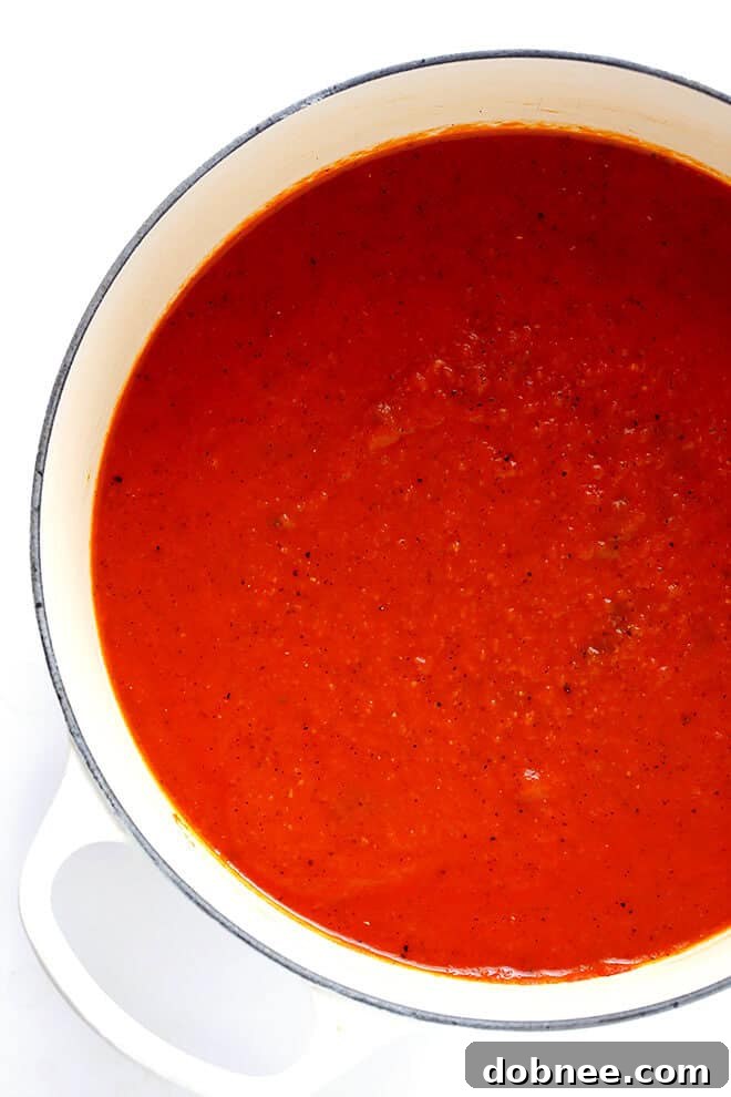 Seasoning the freshly pureed 20-Minute Tomato Soup with salt and pepper, the final touch before serving this delicious and easy meal.