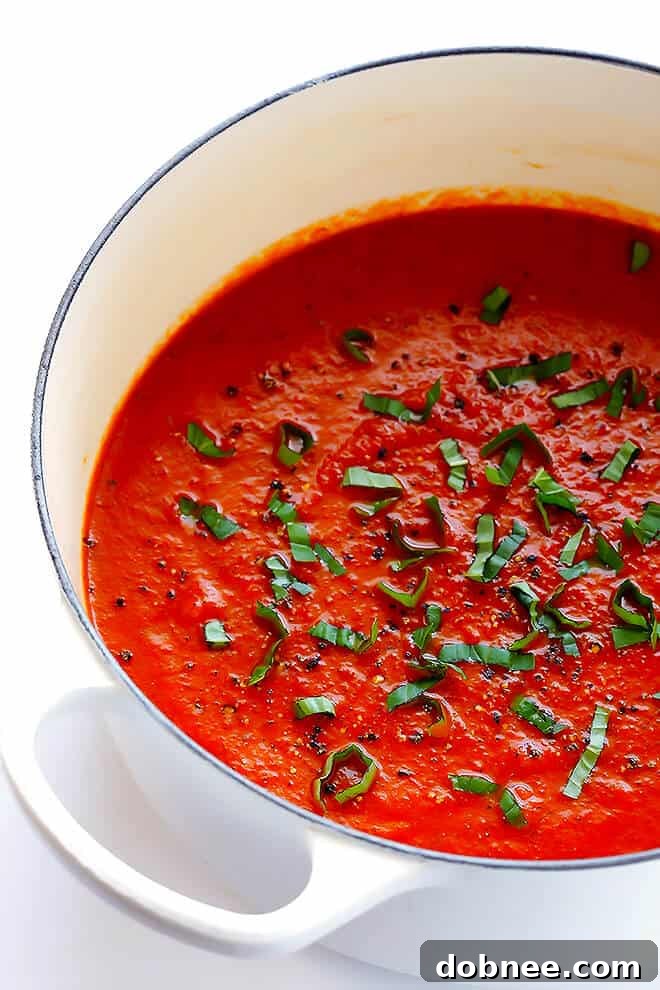 Garnishing the 20-Minute Tomato Soup with a sprinkle of fresh basil leaves, enhancing both its visual appeal and aromatic profile.