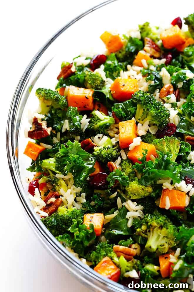 Mixing kale, brown rice, nuts, and dried berries with roasted vegetables and vinaigrette.