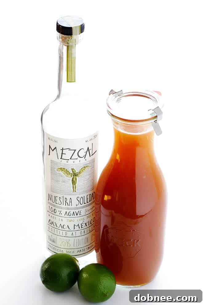 A perfectly crafted Smoky Apple Cider Mezcal Margarita, showcasing its rich amber hue and the enticing sweet ginger salt rim, capturing the essence of a cozy fall evening.