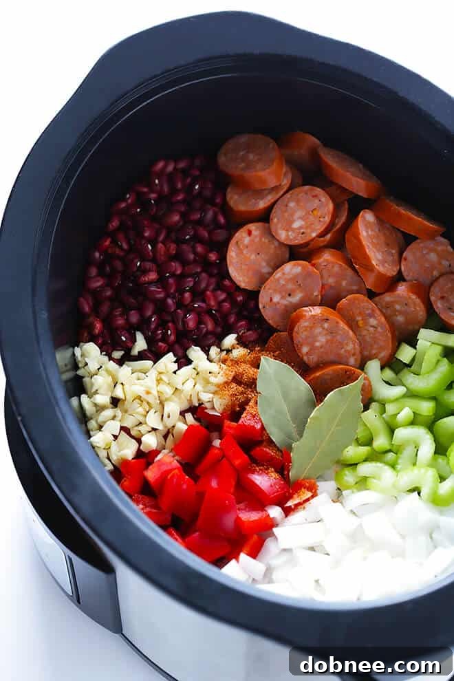 Close-up of vibrant ingredients for slow cooker Red Beans and Rice, including diced bell peppers, onions, celery, and flavorful Andouille sausage.