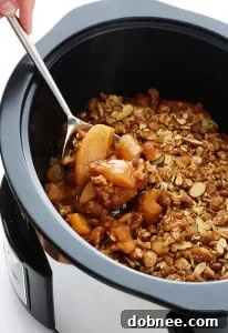 A delicious Slow Cooker Apple Crisp with warm cinnamon apples and a crispy oat-almond topping.