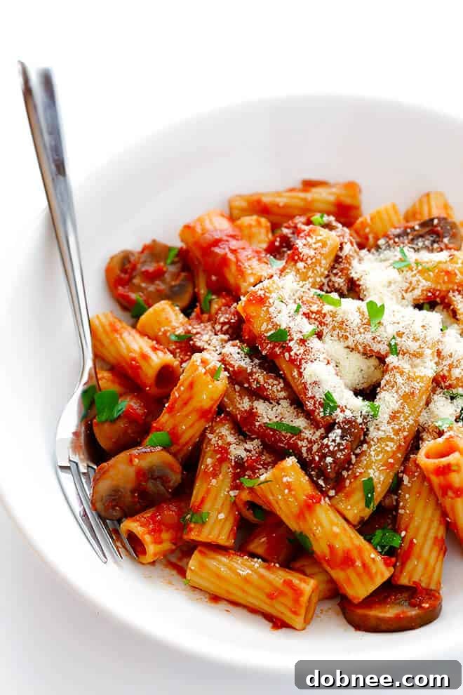 Serving Rigatoni with Mushrooms, Rosemary and Parmesan, topped generously with grated cheese.