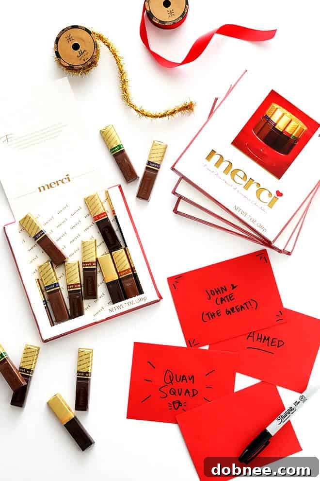 A hand holding a merci chocolate box, ready to be gifted as a sign of appreciation.