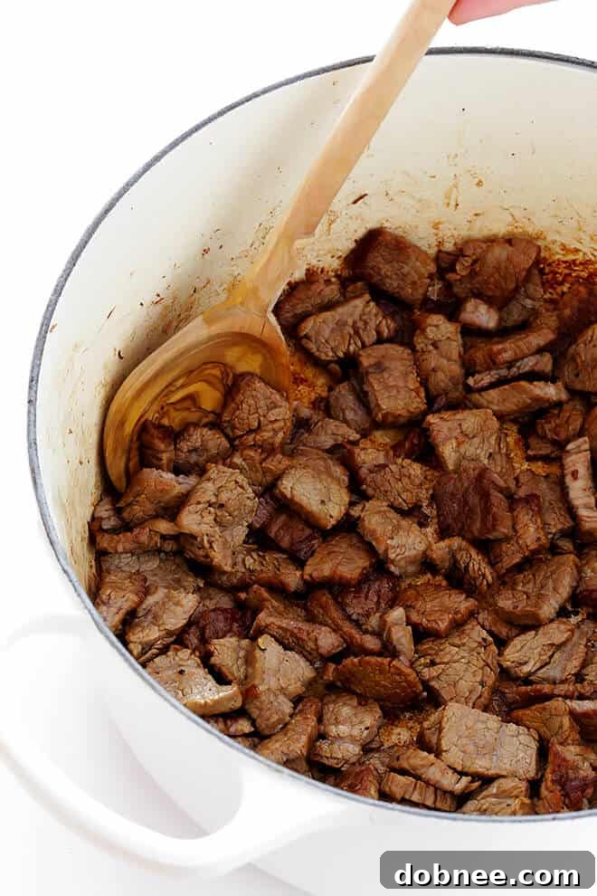 Sautéing thinly-sliced beef steak in a large stockpot for Beef Stroganoff Soup, preparing the base for a flavorful meal.