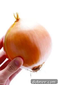 Perfectly diced onion on a cutting board, ready for cooking.
