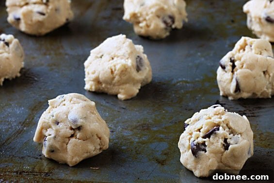 A close-up of a stack of warm, golden-brown chocolate chip cookies.