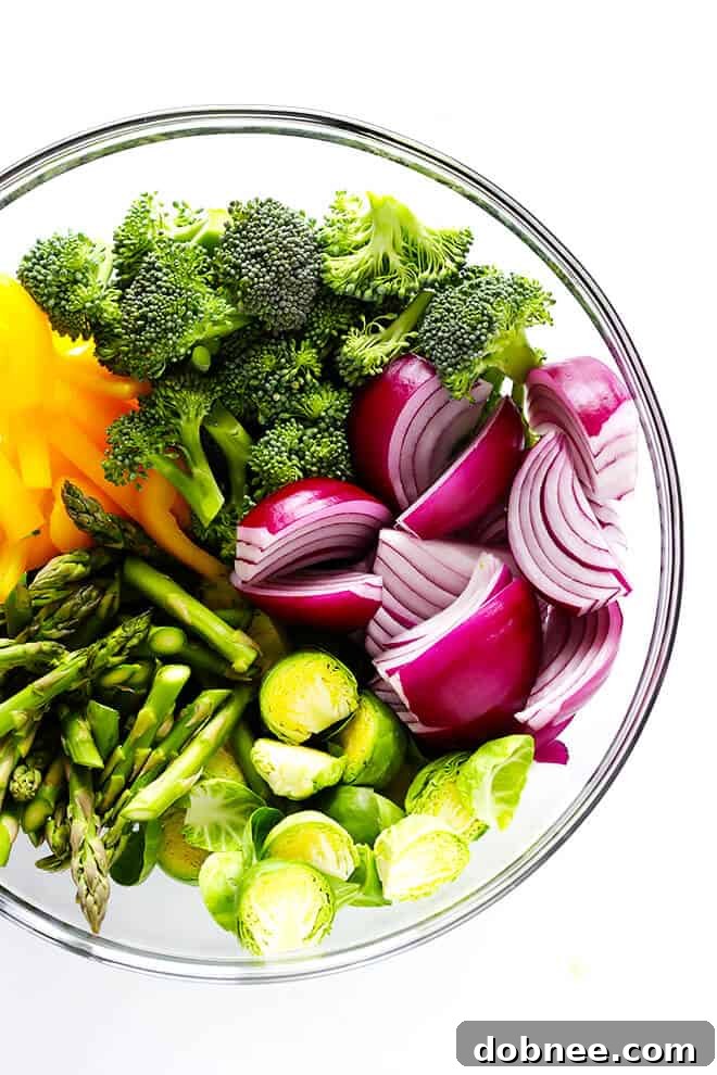 Raw chicken pieces marinating in a rich sesame-soy sauce in a bowl, prior to being combined with fresh vegetables for the sheet pan meal.