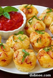 Finished pepperoni pizza puffs in a mini muffin tin, ready to be served.