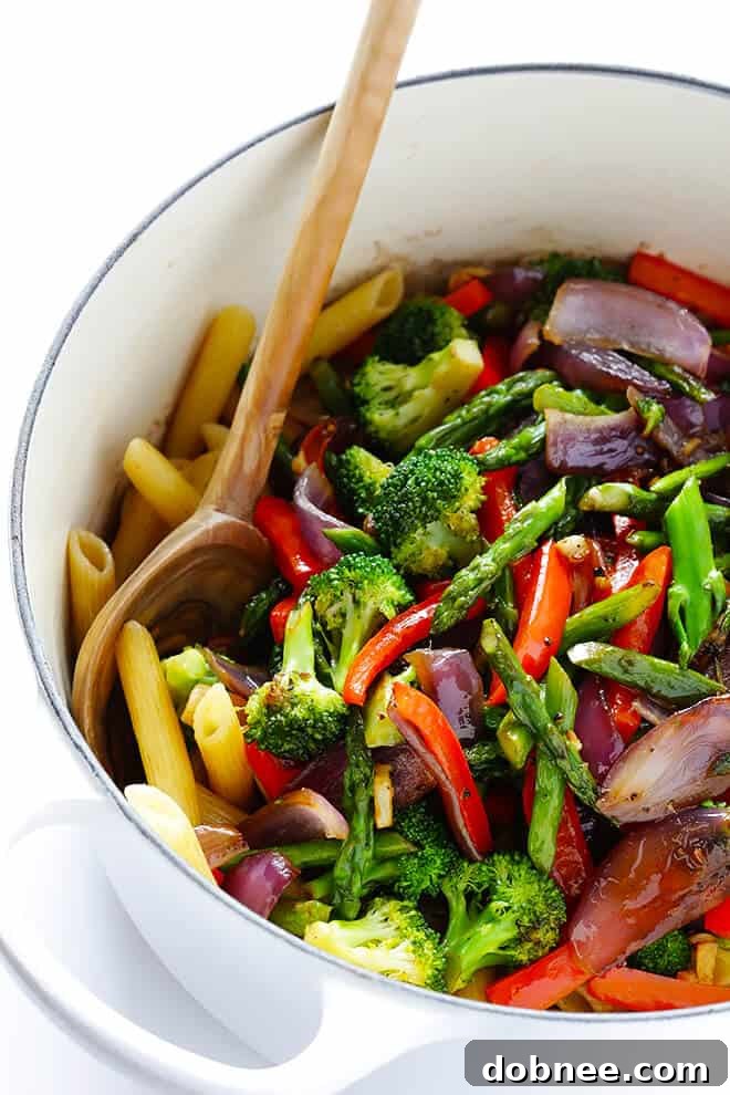 Simple Balsamic Garden Pasta 6 Cooked penne pasta being tossed with olive oil and balsamic vinegar in a large stockpot on the stove, preparing for the vegetable addition.