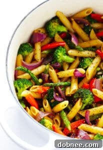 A top-down view of a serving of Balsamic Veggie Pasta with Parmesan cheese and black pepper.