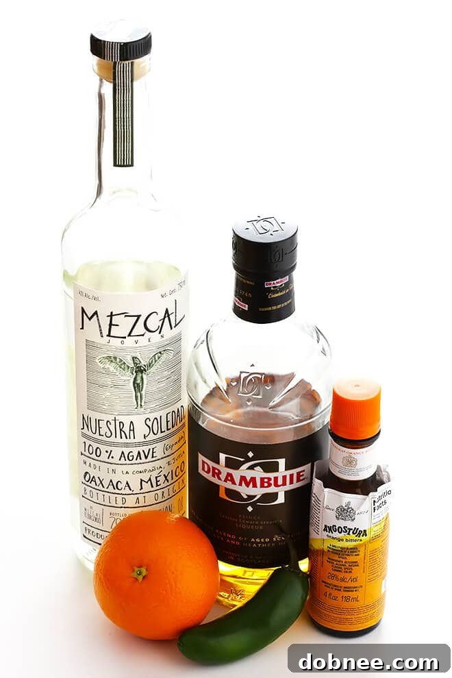 This easy cocktail is made with mezcal, Drambuie, orange bitters, jalapeno, and orange peel. The perfect blend of smoky, spicy, citrusy, and slightly-sweet -- so good!! | gimmesomeoven.com