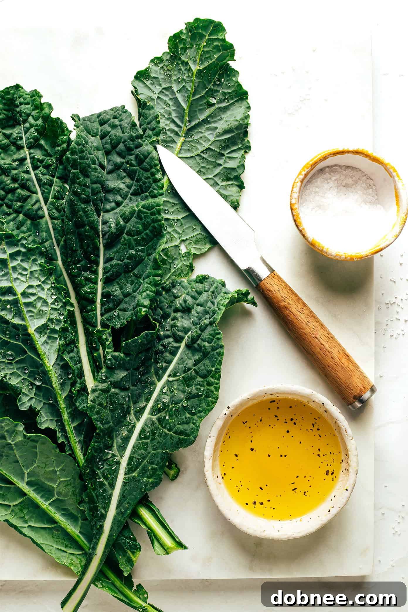 Fresh, vibrant green kale leaves being carefully prepared on a cutting board, ready for making healthy homemade kale chips.