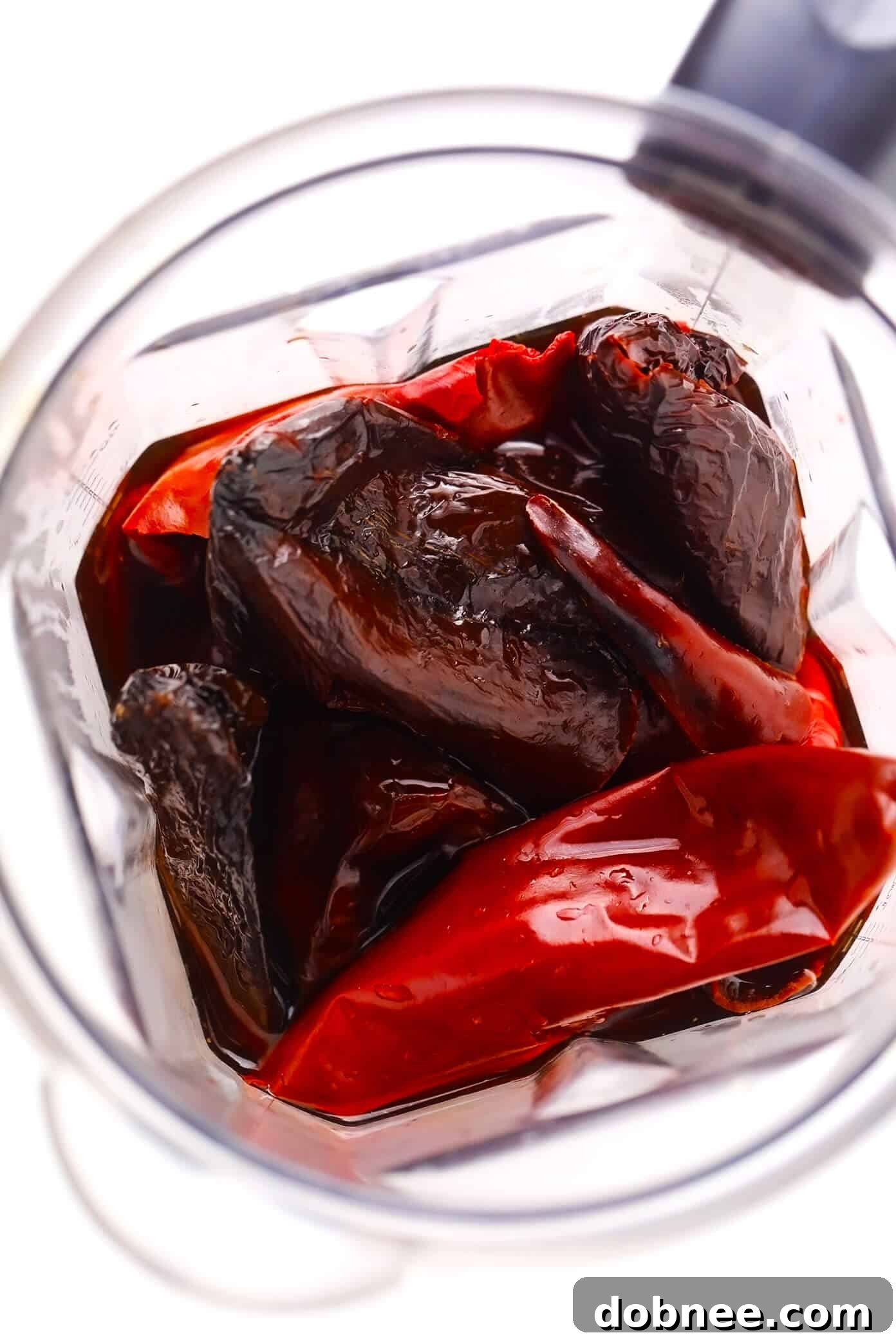 Dried chiles soaking in hot water, ready to be blended into a smooth, flavorful sauce for Pozole Rojo