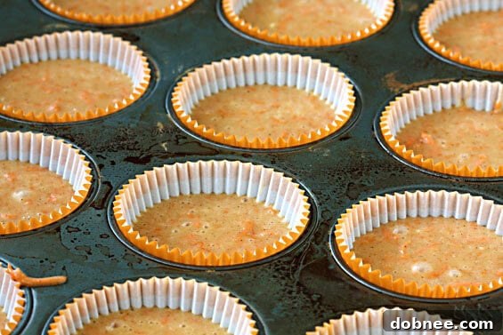 Preparing the ingredients for carrot cupcakes, including finely shredded carrots and a bowl of dry ingredients.