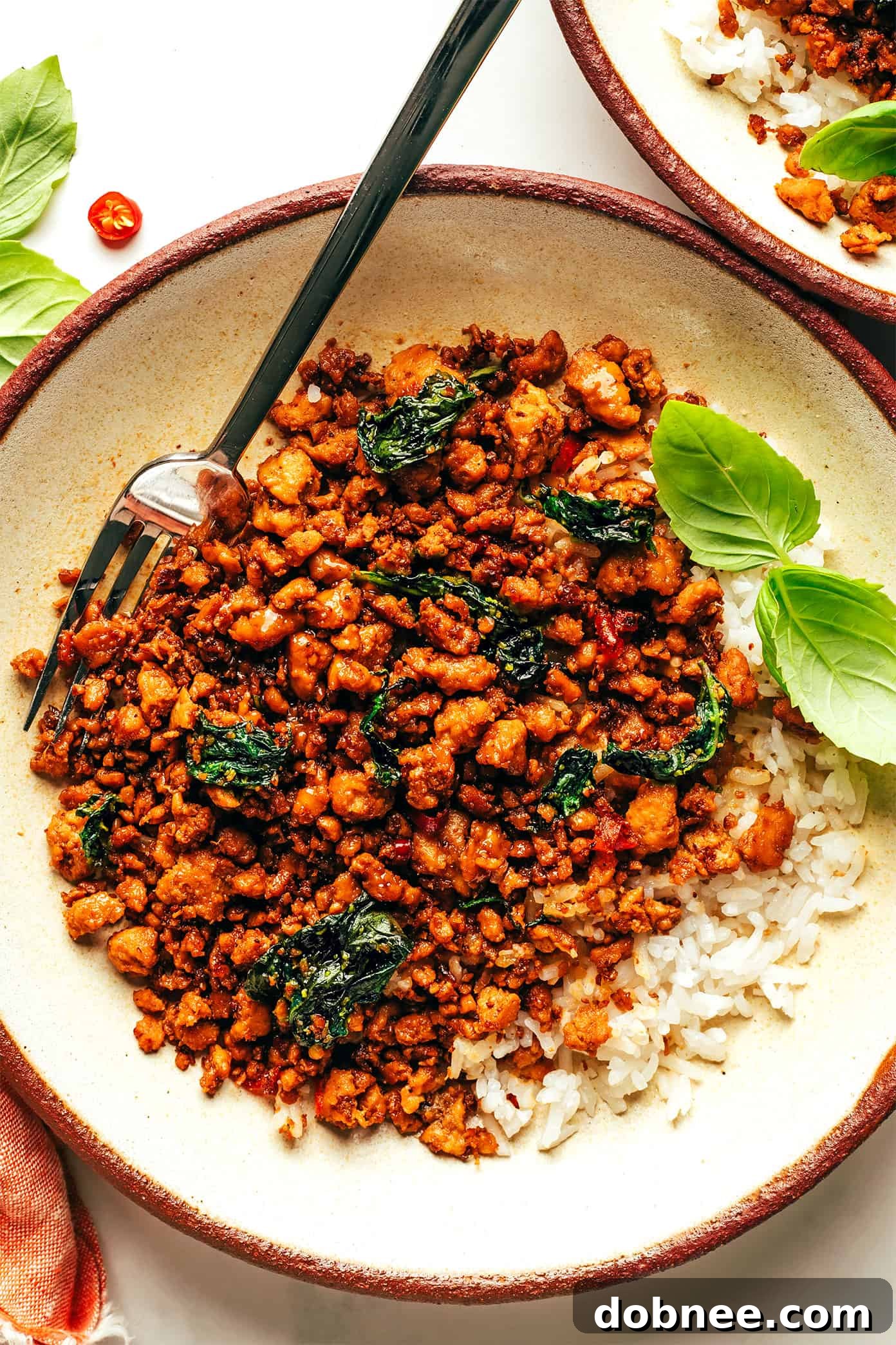 A close-up of the finished Thai Basil Chicken, perfectly stir-fried with rich sauce and wilted basil, ready to be served and enjoyed, showcasing the vibrant colors and appealing texture.