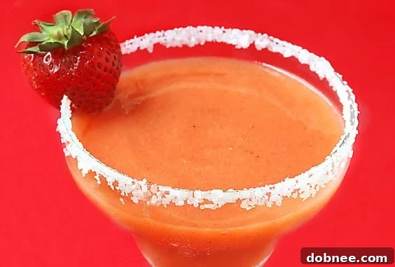 Delicious Strawberry Mango Margaritas in glasses, garnished with fresh fruit, ready to be enjoyed.