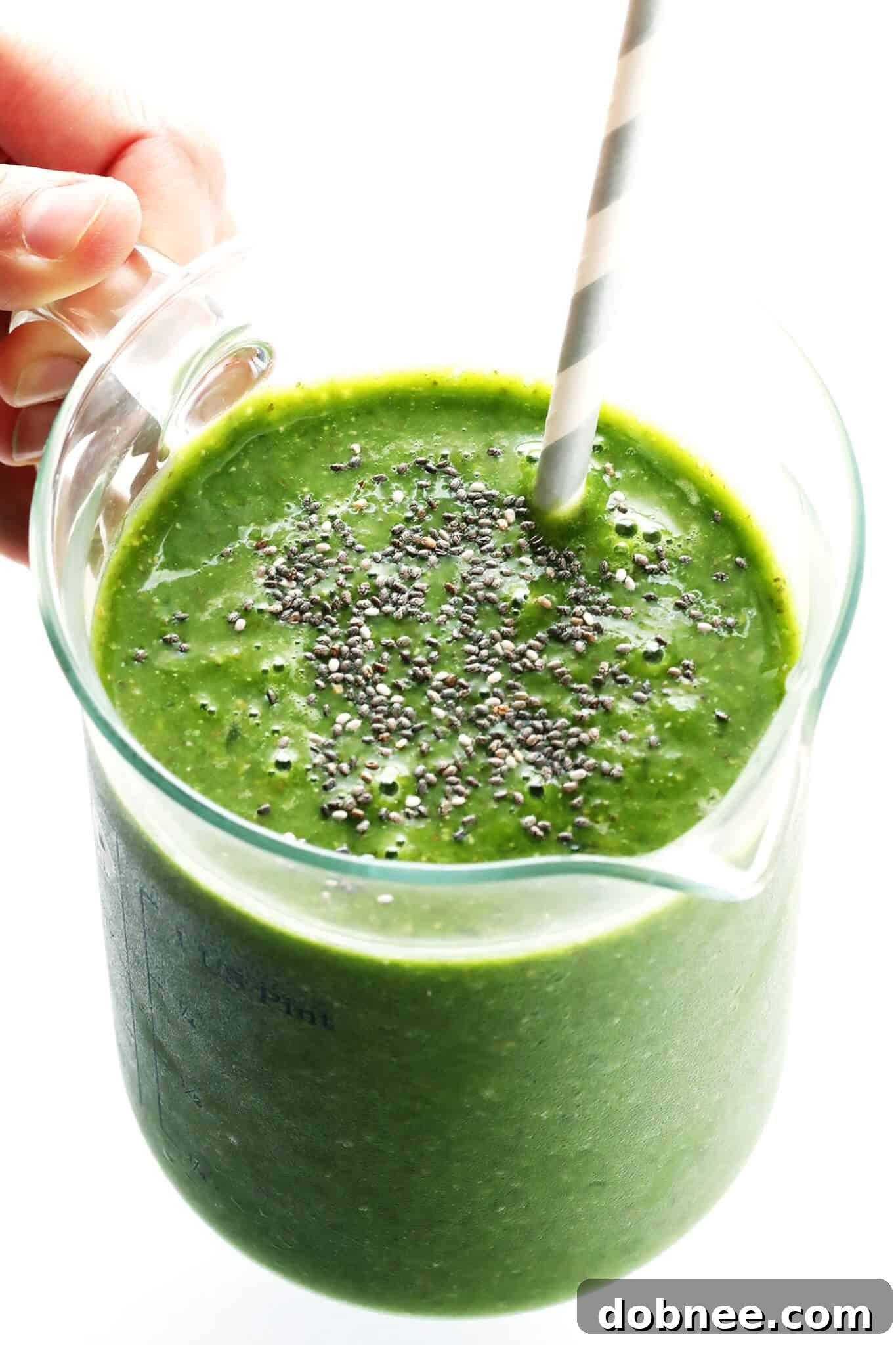 The perfectly blended Matcha Ginger Green Smoothie being poured from the blender into a serving glass.