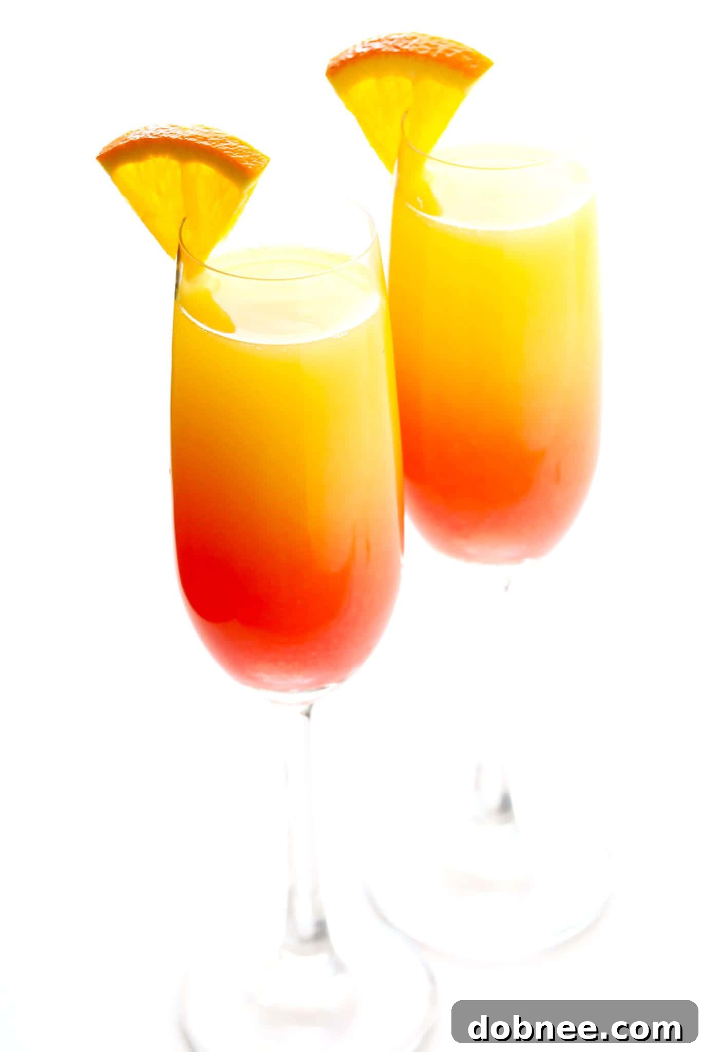 Agave Dawn Mimosa 2 Tequila Sunrise Mimosa in a champagne flute with an orange slice garnish.