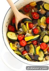 A vibrant bowl of easy ratatouille, a rustic summer vegetable stew, served with a side of crusty bread.