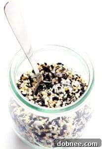 A close-up shot of Everything Bagel Seasoning in a small bowl, showcasing the blend of sesame seeds, poppy seeds, minced garlic, and onion.