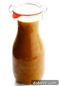 Delicious Thai Peanut Dressing in a jar with limes and ingredients.