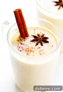 Homemade Chai Eggnog, garnished with cinnamon stick and star anise, in a festive mug.