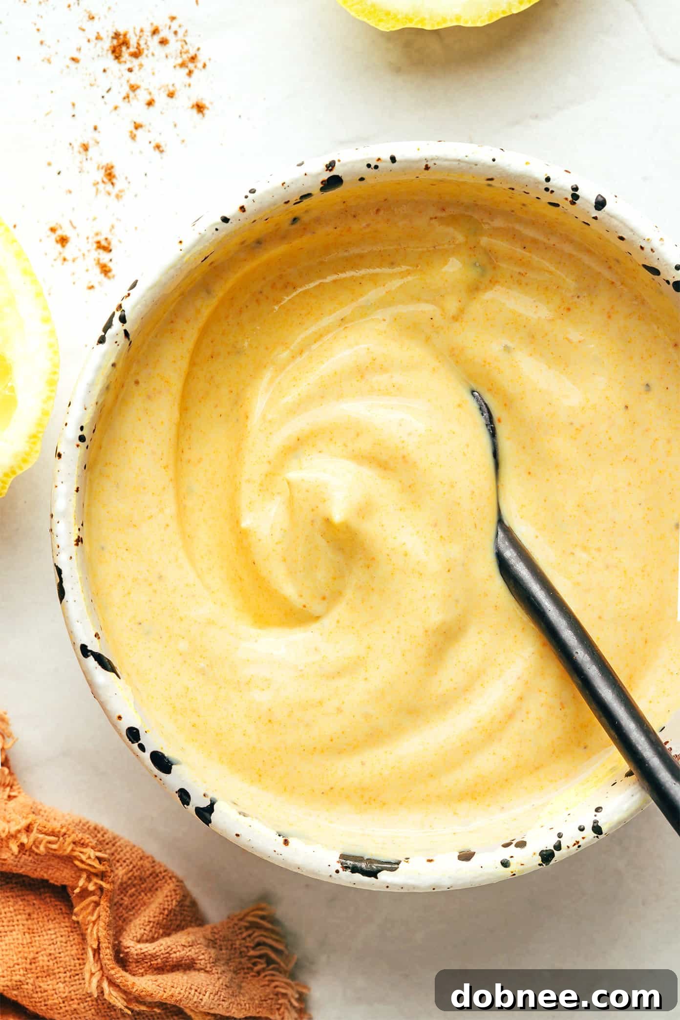 Creamy Greek yogurt curry sauce in a bowl, made with lemon juice, honey, and aromatic spices.