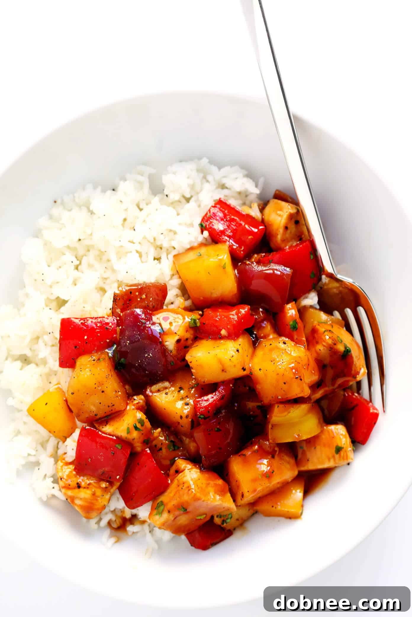 Close-up shot of the Hawaiian BBQ Chicken Bowls, showcasing tender chicken, vibrant bell peppers, and juicy pineapple, ready to be served over rice.