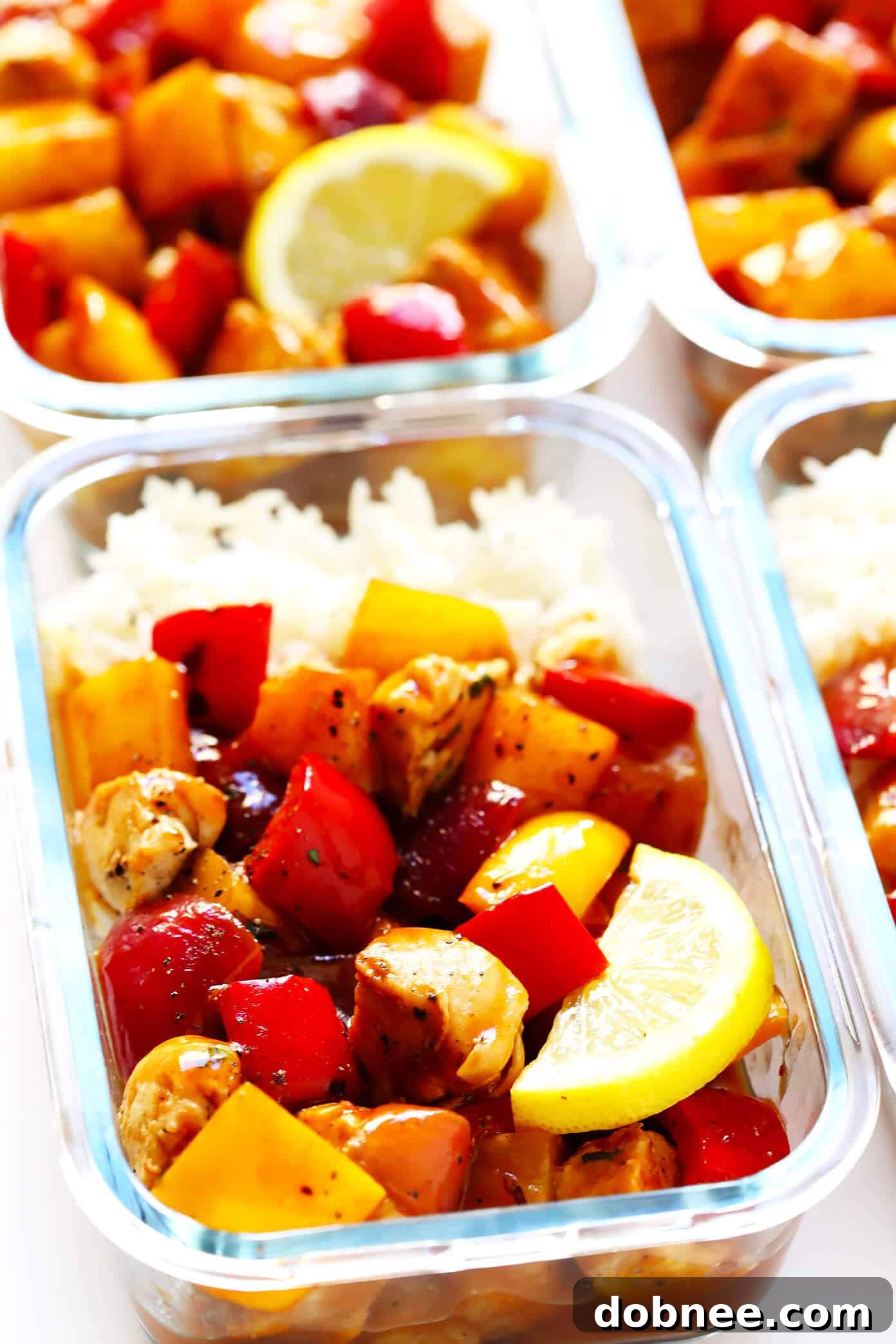 Meal prep containers filled with Hawaiian BBQ Chicken Bowls, showcasing the balanced and colorful components for healthy lunches throughout the week.