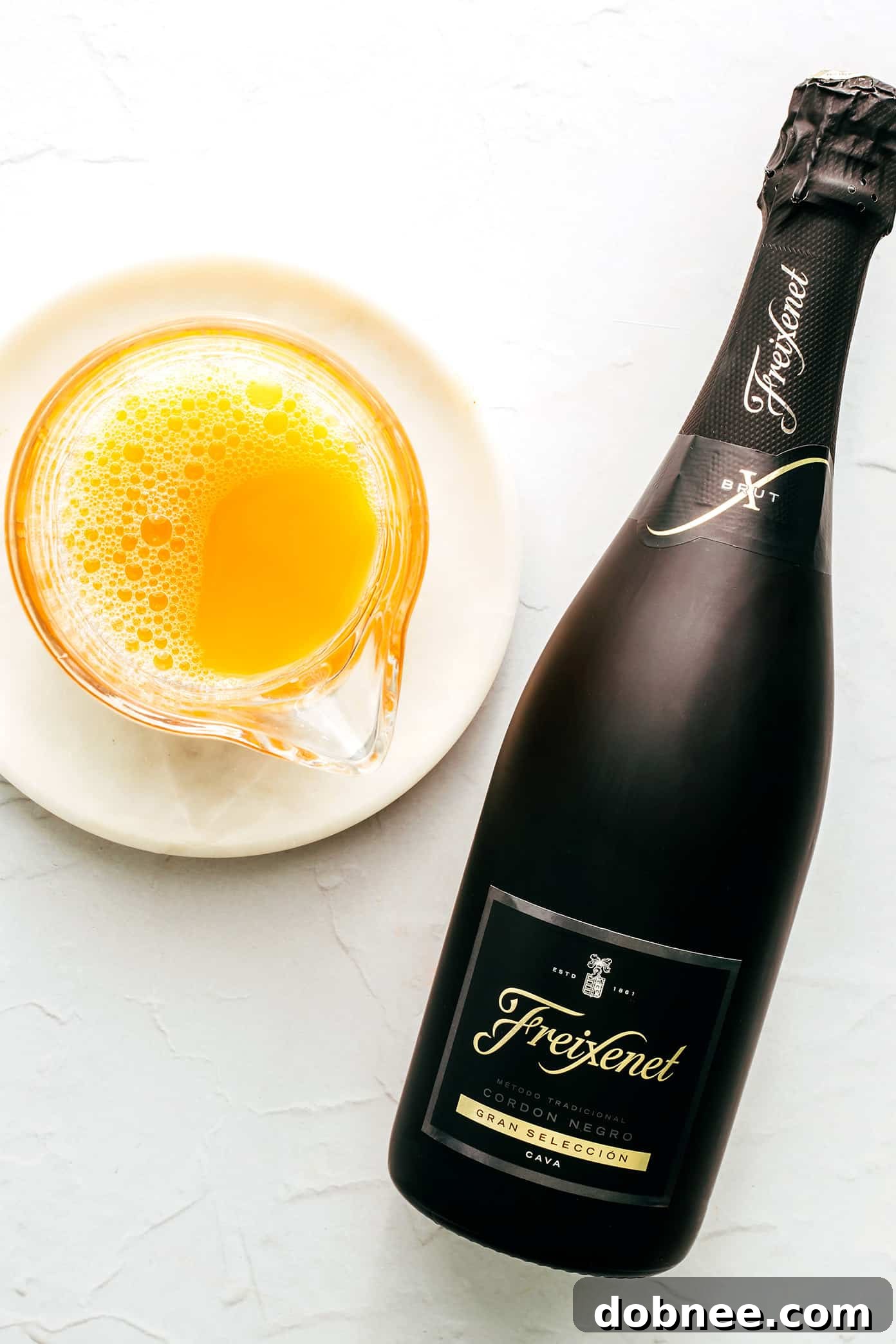 Close-up of three mimosa glasses, showing the vibrant orange juice and sparkling wine layers