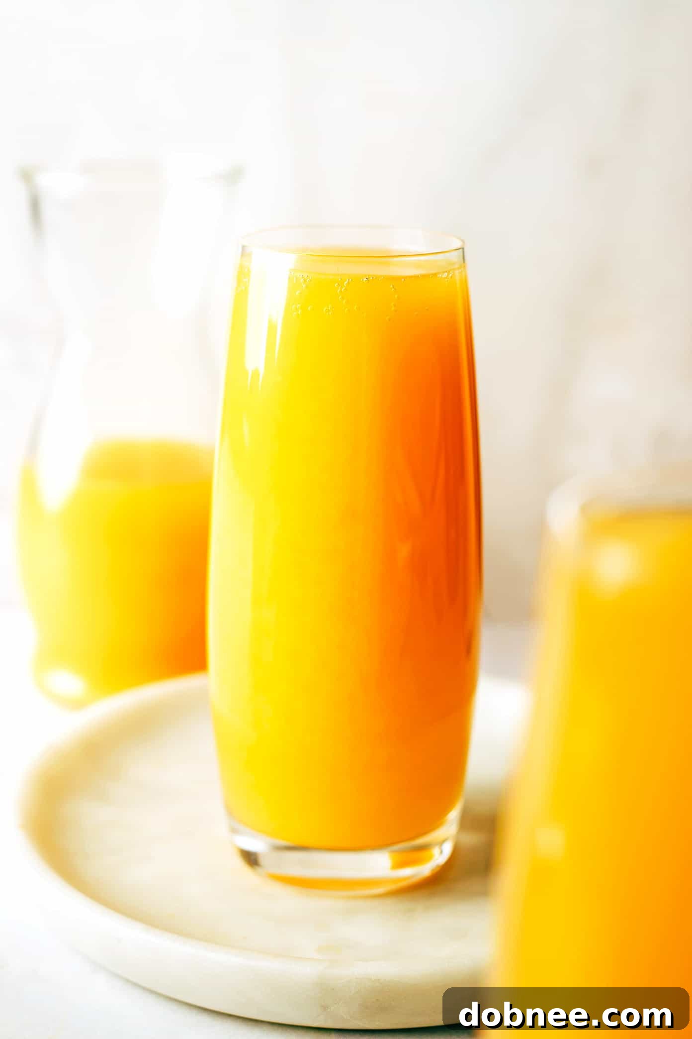Several glasses of mimosas arranged artfully on a table, ready for a party